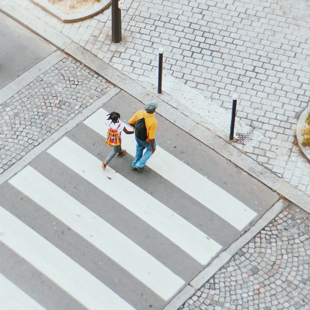 Man and girl on a pedestrian crossing, almost across the street