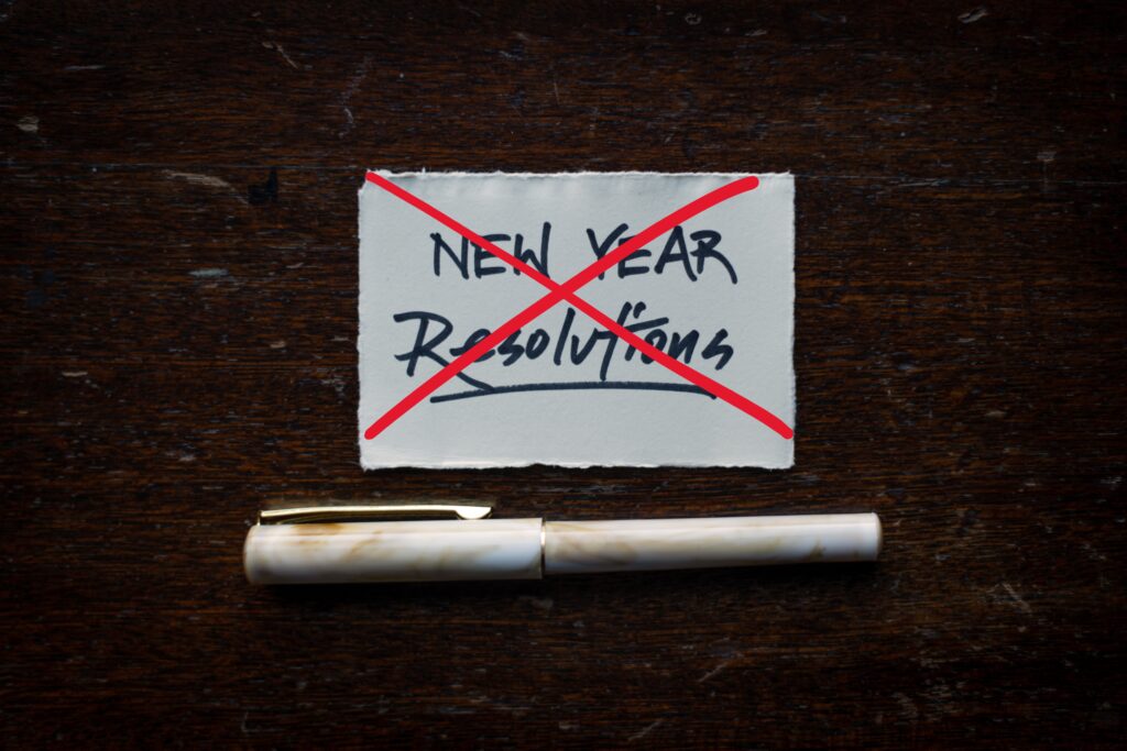 ‘New Year Resolutions’ written on a piece of paper, crossed out