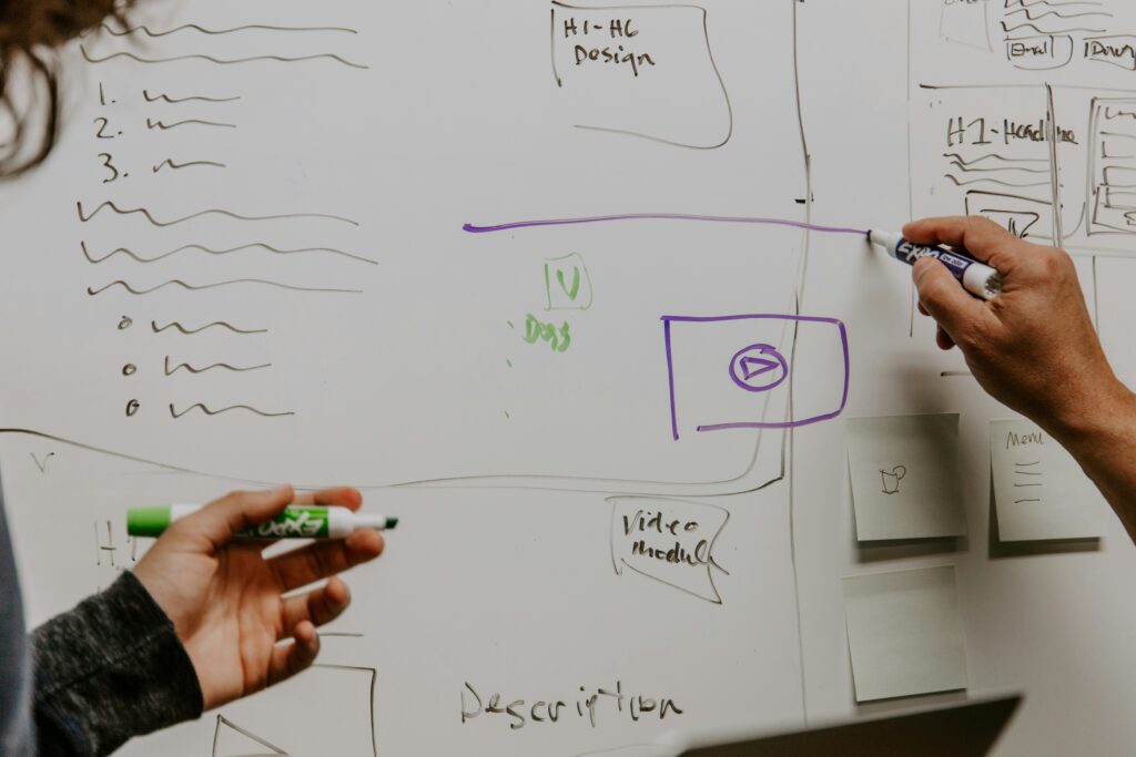 Two people drawing on a whiteboard
