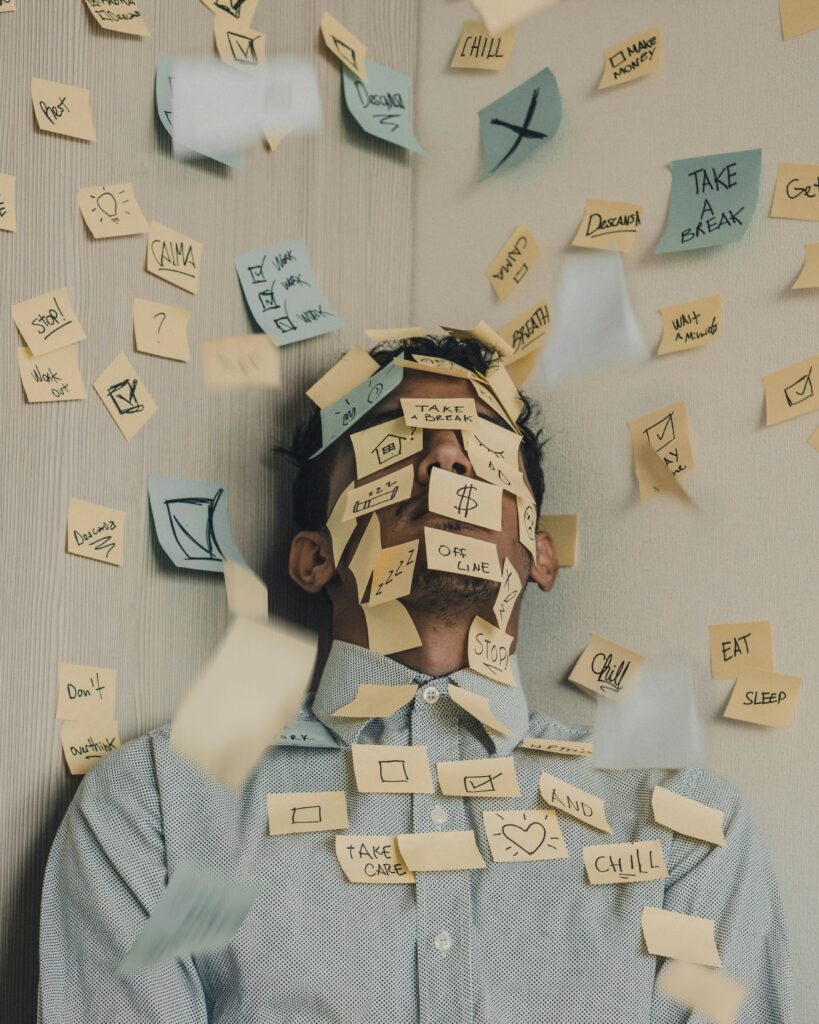A man covered in post-it notes representing task overload and burnout