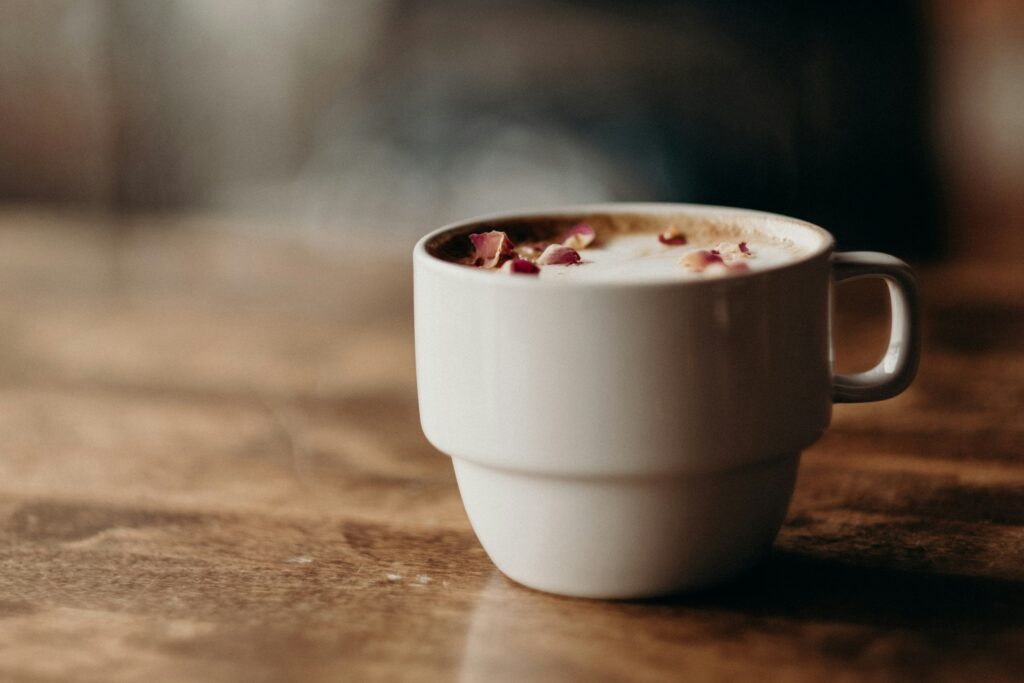 White ceramic mug filled with coffee on a wooden table