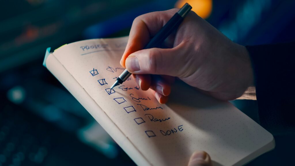 Hand checking off items from a to do list with a dark pen Photo by Jakub Żerdzicki on Unsplash
